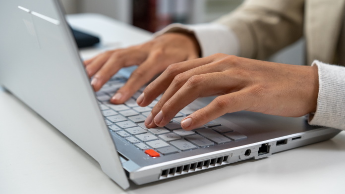 Hands on a laptop keyboard