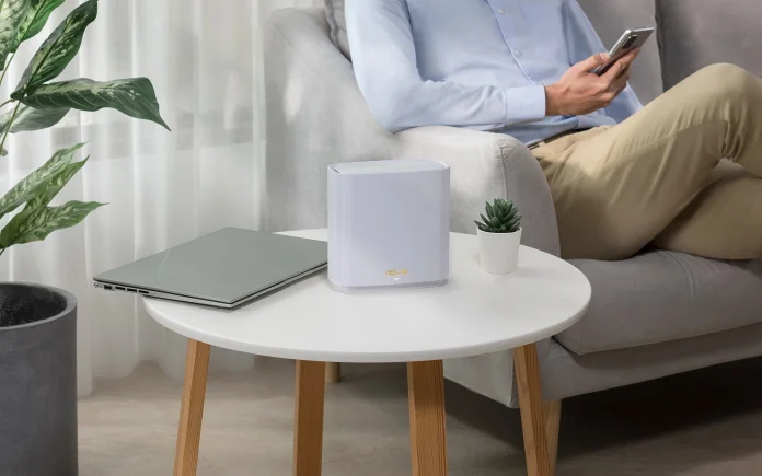 Man in chair with ASUS mesh WiFi router nearby on a table