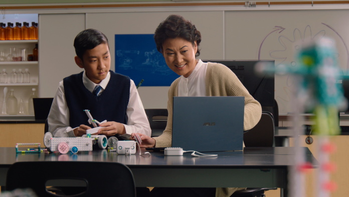 Educator and student using a laptop in a STEM lab