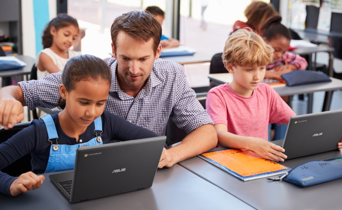 Educator working with a classroom of students using laptops