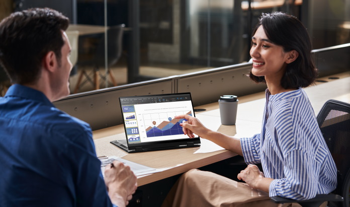 Woman doing a business presentation with a client in a public location using an ASUS convertible laptop