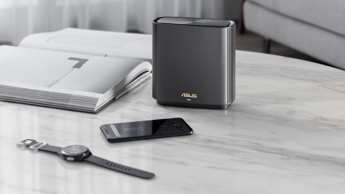 ASUS ZenWiFi mesh WiFi system on a table with smartphone, watch, and laptop