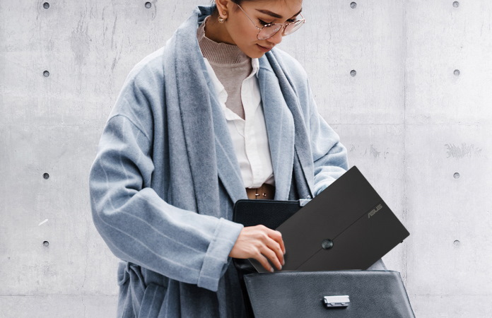 Woman putting her ASUS portable monitor into a satchel