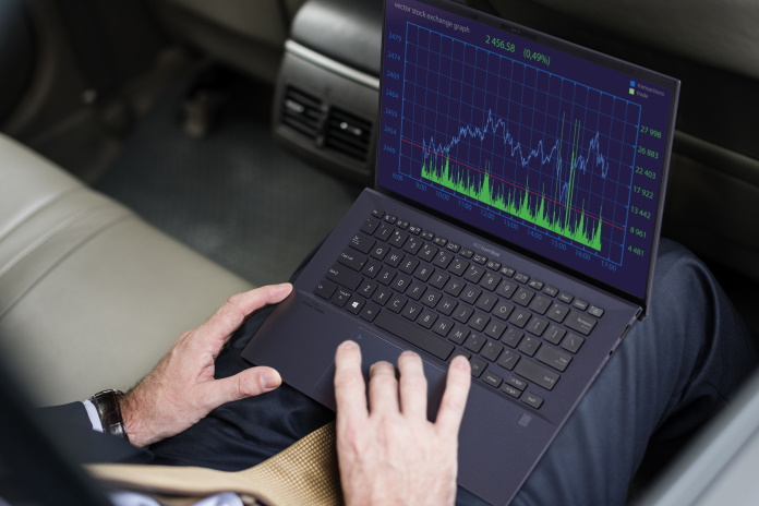 A person running a business uses an ExpertBook laptop in a car