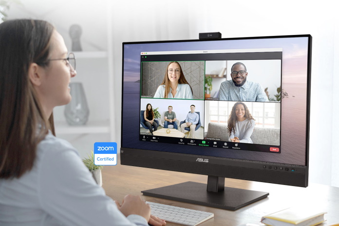 Woman teleconferencing with coworkers with an ASUS monitor