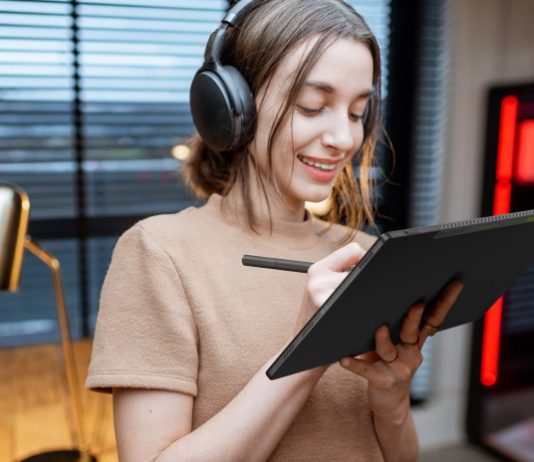 Young woman listening to music and working with a stylus on her Vivobook 13 Slate OLED