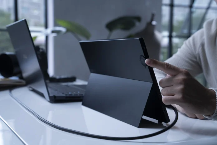 Man using the ASUS Dial on the ProArt Display PA148CTV portable monitor