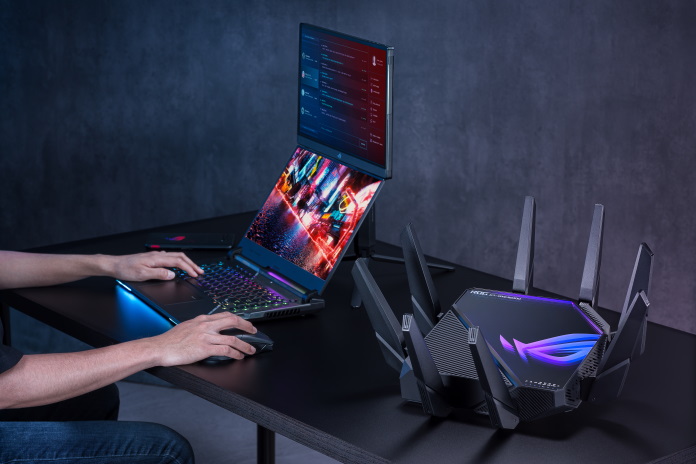 Gracz grający na notebooku obsługującym Wi-Fi 6E podłączonym do routera bezprzewodowego ROG Rapture GT-AXE16000