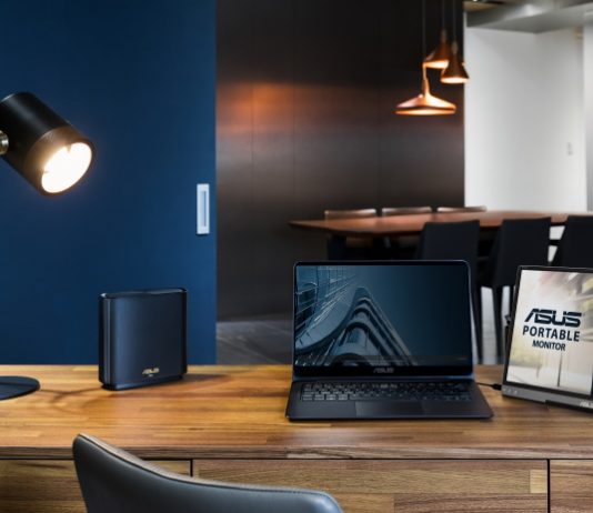 ASUS router, laptop, and portable monitor at a home office desk