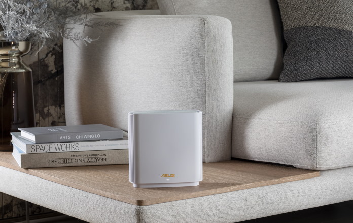 The ZenWiFi XT9 mesh WiFI system on and end table next to a stack of books