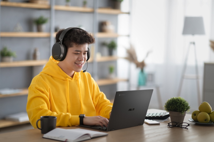 Man with a headset on playing games on his Chromebook at a desk