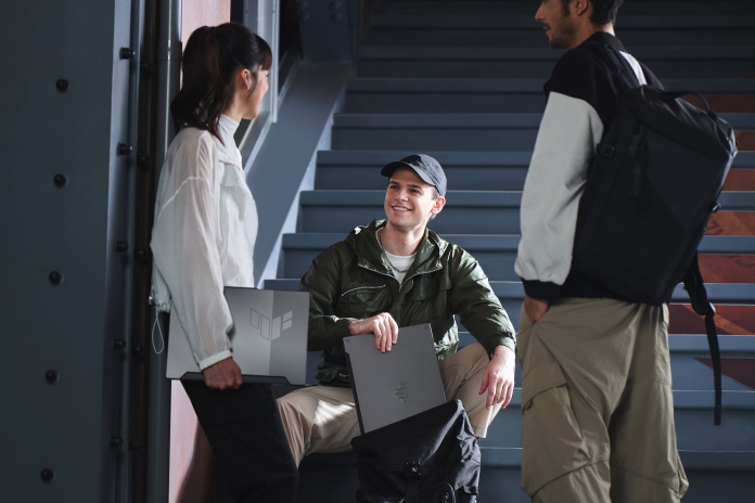 A group of friends hanging out in a stairwell with TUF Gaming A15 laptops