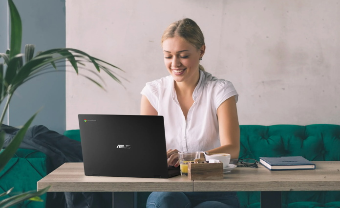 Woman sitting at a table using the ASUS Chromebook CX1 