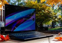 The Zenbook Pro 16X OLED laptop sitting on a stone wall in front of trees