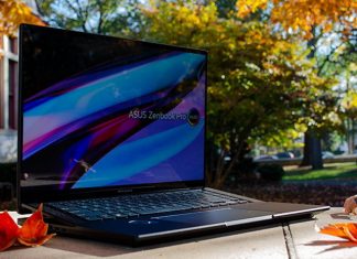 The Zenbook Pro 16X OLED laptop sitting on a stone wall in front of trees
