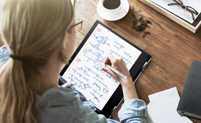 Woman write notes on her Chromebook using a stylus