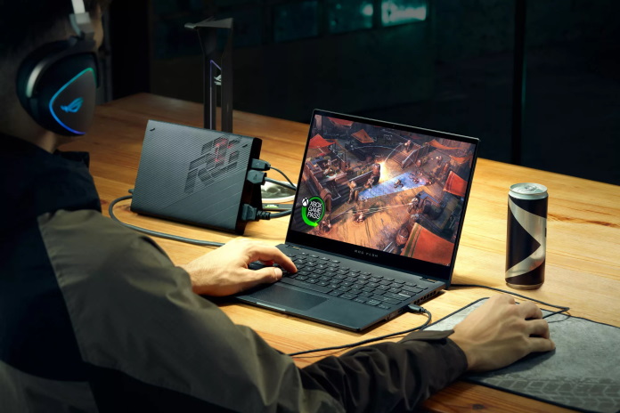 Gamer playing on the ROG Flow X13 laptop connected to the ROG XG Mobile eGPU and docking station