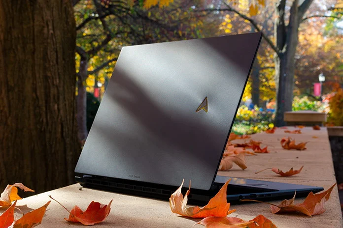 Zenbook Pro laptop on a stone retaining wall with autumn leaves scattered around
