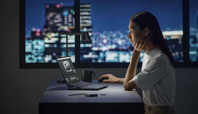 Young woman working on a creative project in her office with the Zenbook Pro 14 Duo OLED laptop