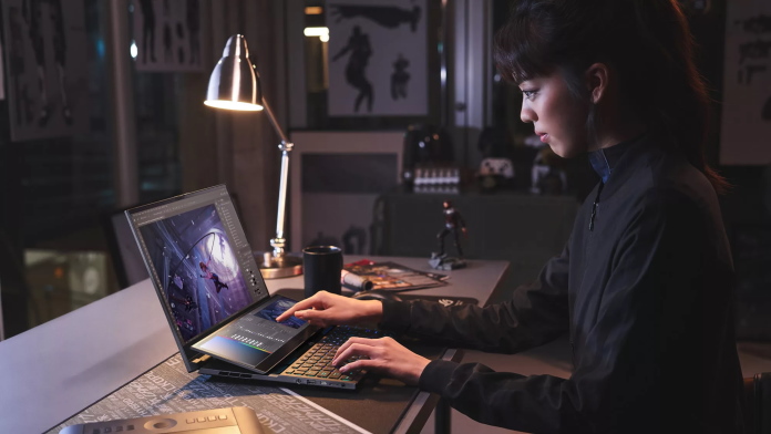 Young woman working on a creative project at her desk with the ROG Zephyrus Duo 16 laptop 
