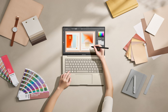 The ASUS Zenbook 14X OLED laptop flat on a table and being used for design work 