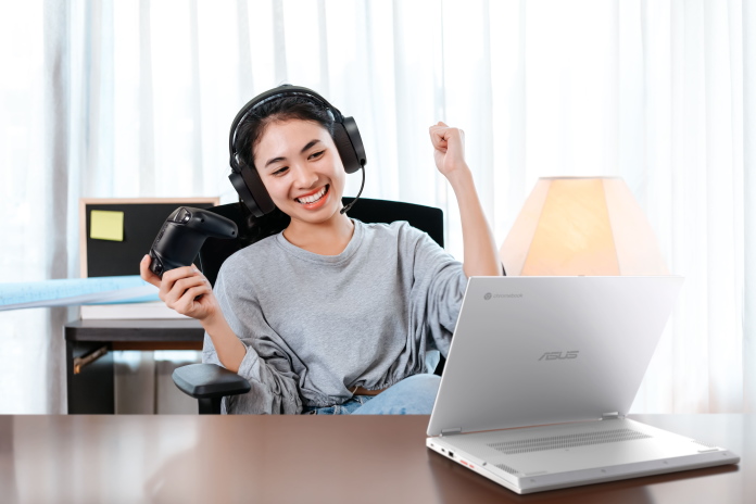 Girl celebrating while playing PC games using the Chromebook Vibe CX34 Flip in stand mode