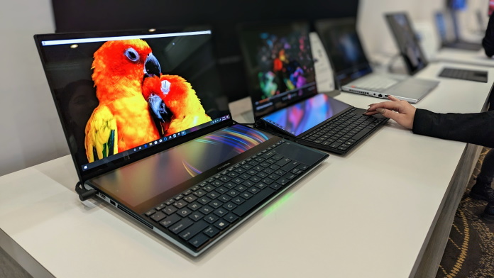 A range of ASUS OLED laptops arranged on a table at CES 2023