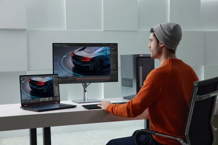 A young man working on a commercial at a desk with a ProArt Station desktop, ASUS laptop, and a ProArt Display