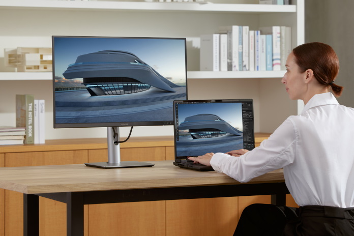 An architect working at her desk using an ASUS laptop and the ProArt Display PA279CRV