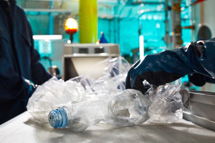 Workers separating materials for recycling at a recycling facility