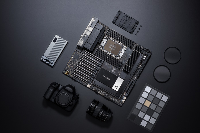 The ASUS Pro WS W790E-SAGE SE workstation motherboard with a range of creative tools arranged around it on a table