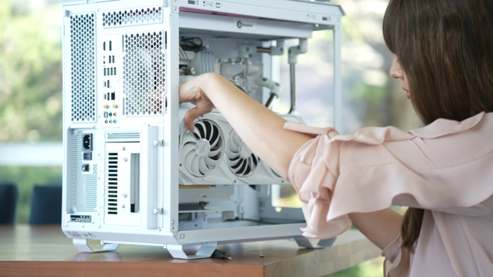 Christina installing the ROG Strix GeForce RTX 3090 White OC Edition graphics card into the chassis