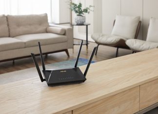 An ASUS extendable router on a low table in a living room with couch and chairs behind