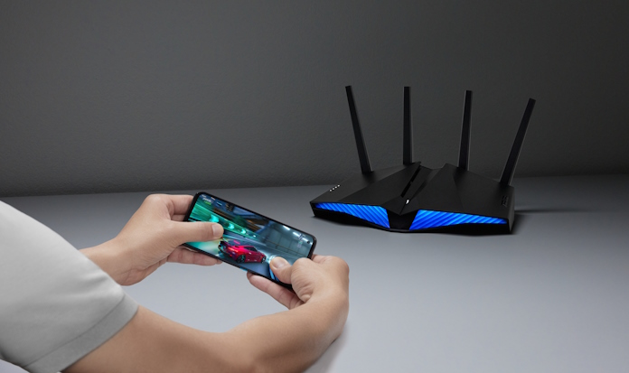 A gamer playing on a smartphone with an ASUS router in the background