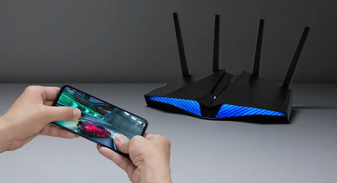 A person playing games on a smartphone near the ASUS RT-AX82U mesh router