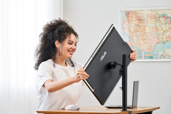 Woman moving the MB249C between portrait and landscape modes