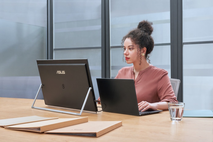 Woman working at her laptop connected to the ZenScreen MB249C in kickstand mode