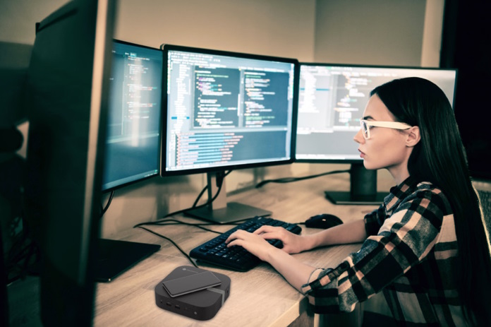 Woman working at a workstation with four monitors powered by the ASUS Chromebox 5