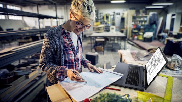 A woman using the ExpertBook B6 Flip laptop in a commercial kitchen