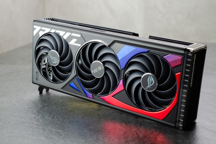 The ROG Strix GeForce RTX 4070 Ti graphics card standing upright on a reflective surface