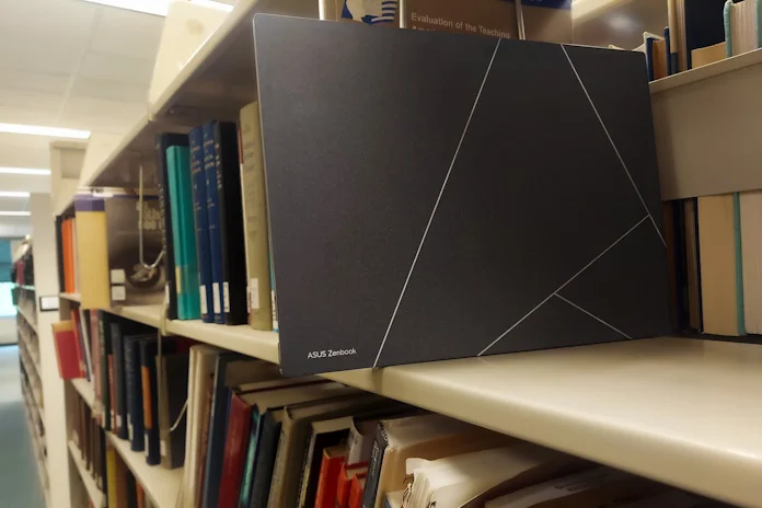 Zenbook S 13 OLED laptop on a bookshelf in a college library