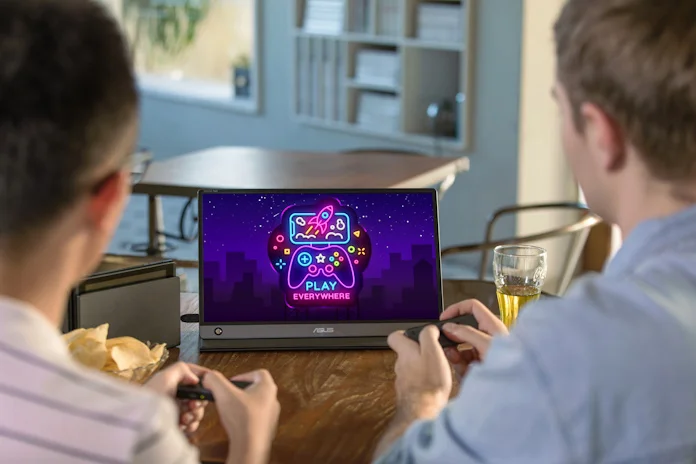 Two gamers playing with their console using a ZenScreen portable monitor so that they can play using a dining room table