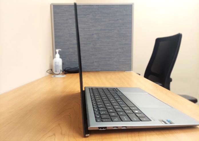 Side view of the Zenbook S 13 OLED showing its thin profile and screen as it sits on a desk in a college office 