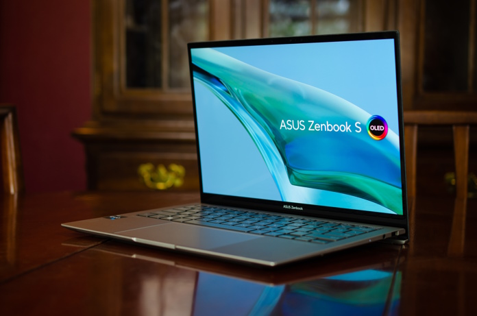 Zenbook S 13 OLED laptop sitting open on a table from a front angle view with an antique hutch in the background