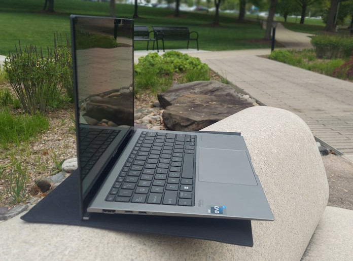 Laptop resting on a stone bench on a college campus 