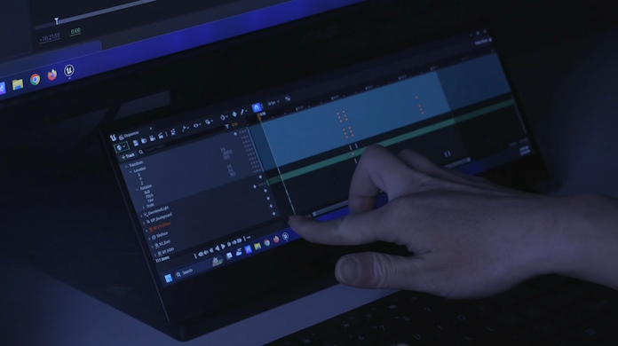 A college student using a ProArt Display PA147CDV to scrub a timeline using the touchscreen interface