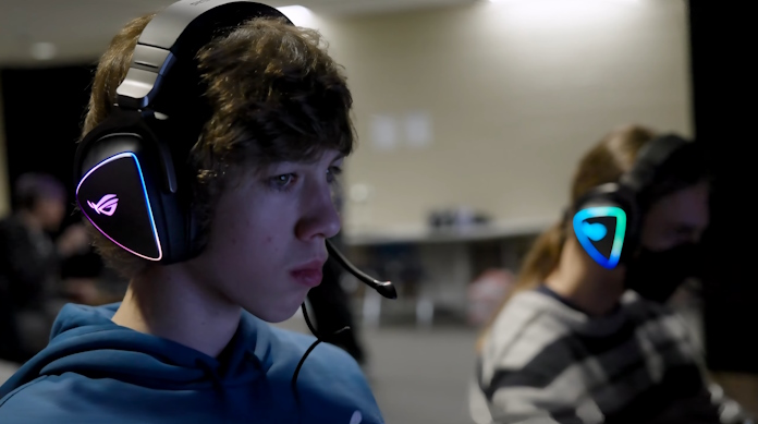 A young man tracking the action in a game with an ROG Delta headset that lets him communicate easily with teammates