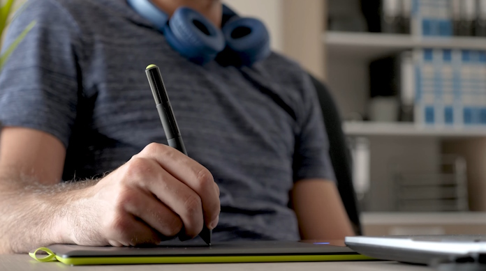 A student using a stylus to sketch a logo for the Oswego High School esports club