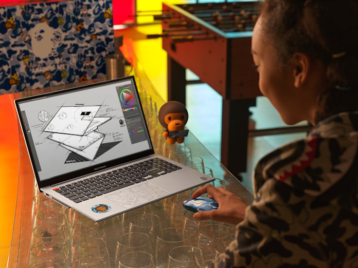 A young woman pursuing a creative project using the Vivobook S 15 OLED BAPE Edition laptop inside a hangout room with a foosball table in the background