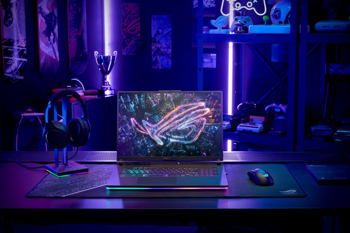 An ROG Strix G16 laptop on a desk with ROG headset and gaming mouse 